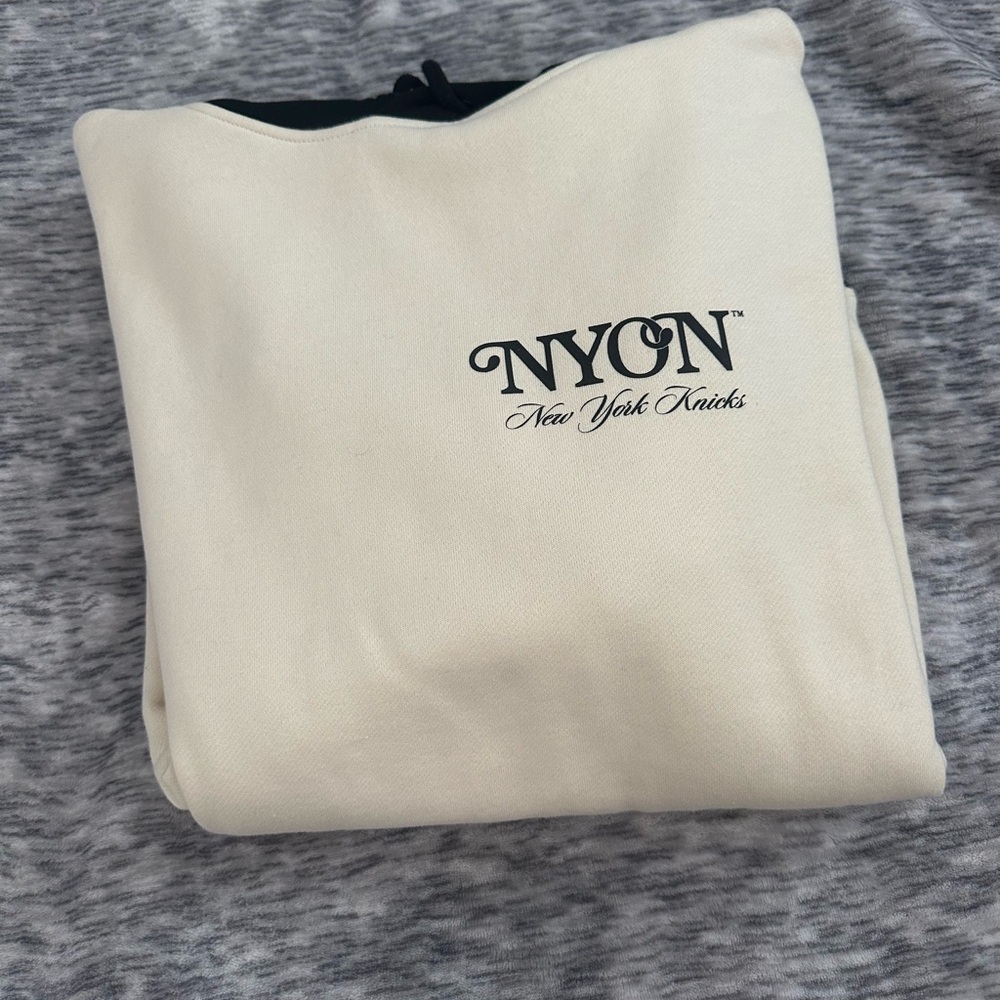 Cream NYON X New York Knicks hoodie with blue and orange block sleeves
